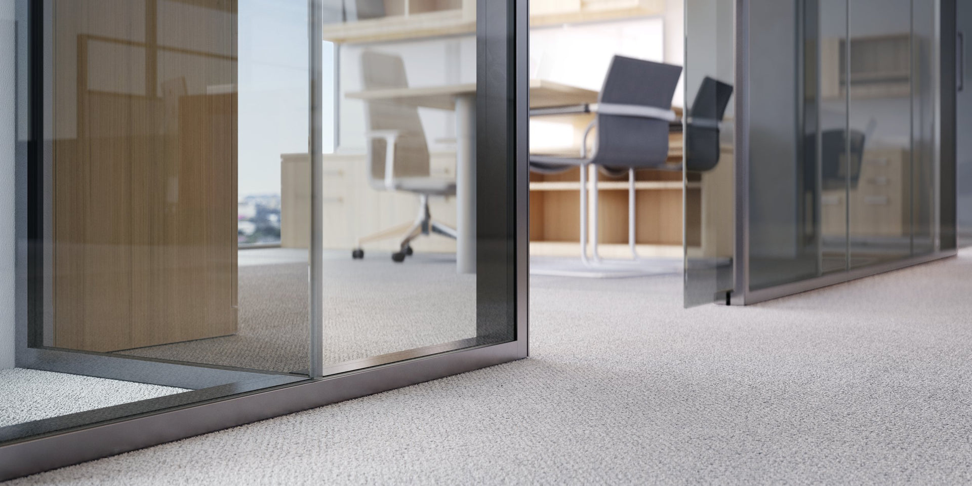 Modern office interior with glass doors leading to a meeting room.