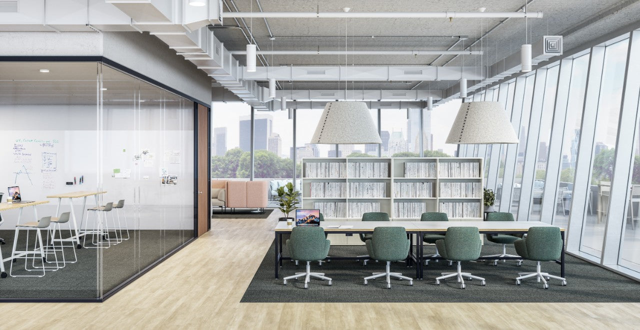 Modern office space with large windows, desks, and chairs.
