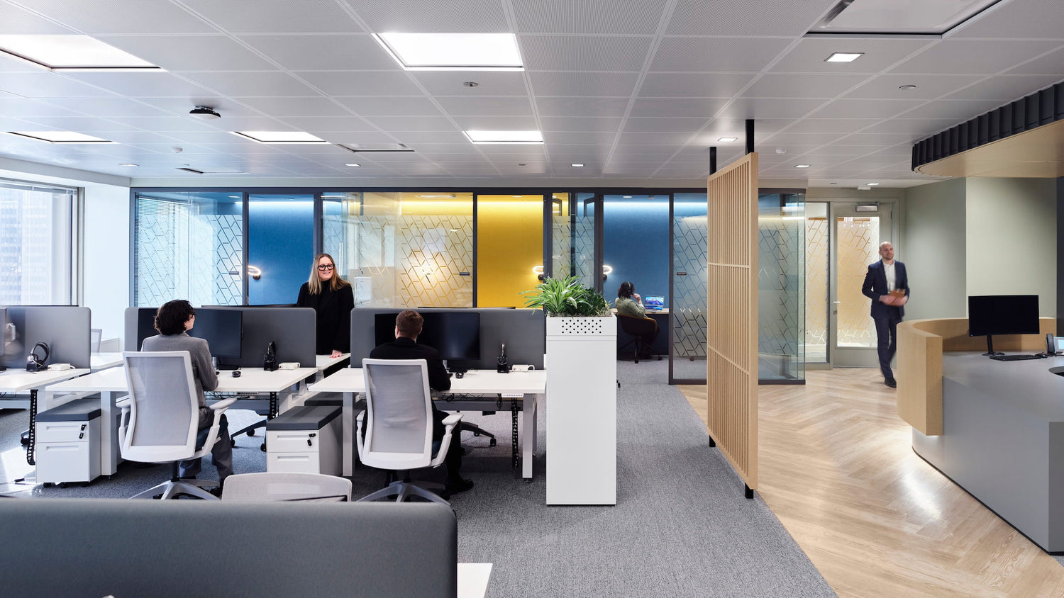 Modern office interior with employees working at desks.