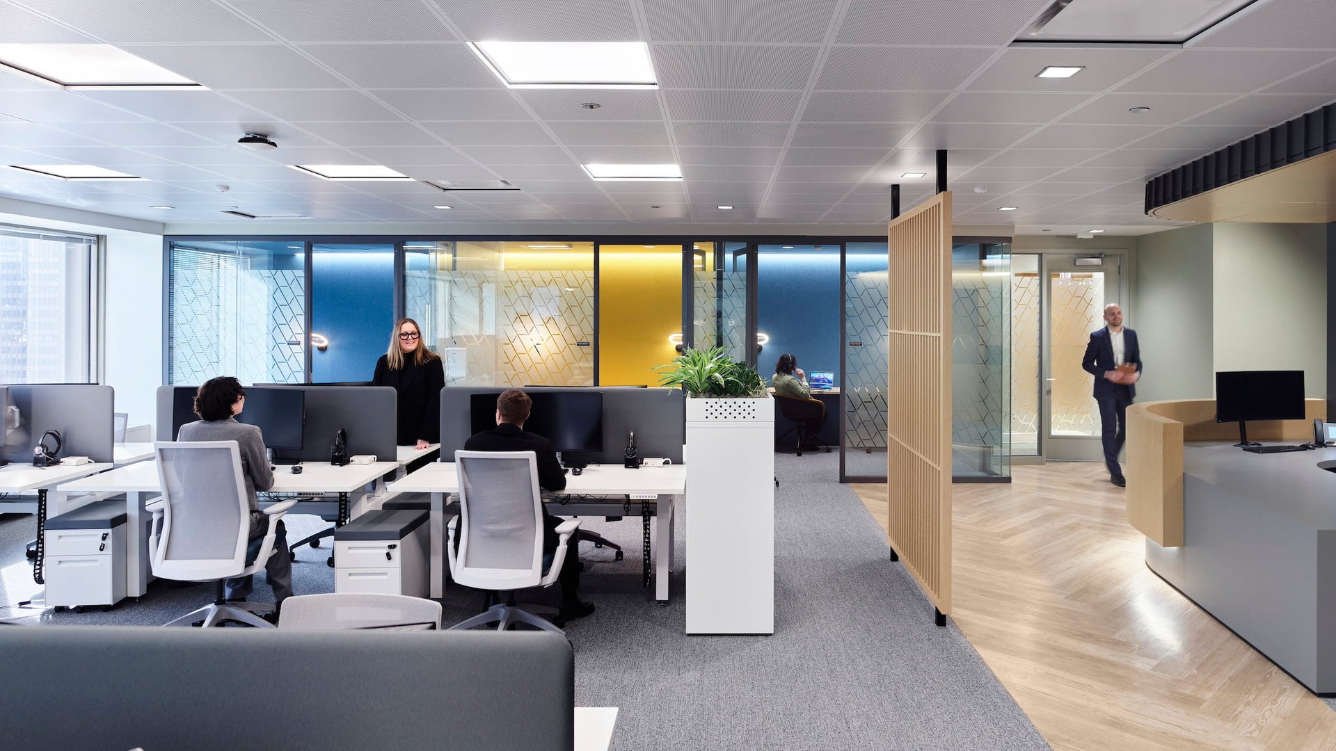 Modern office interior with employees working at desks.