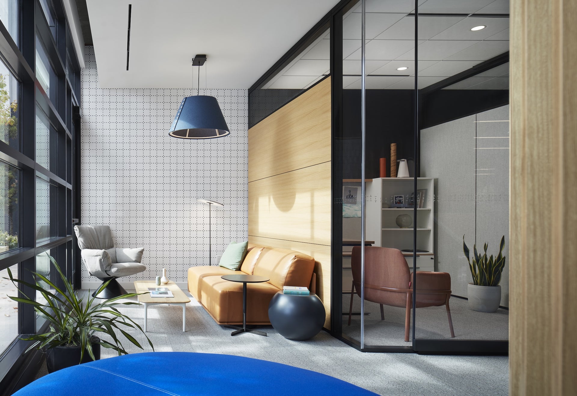 Modern office interior with a sofa, coffee table, and office chair.