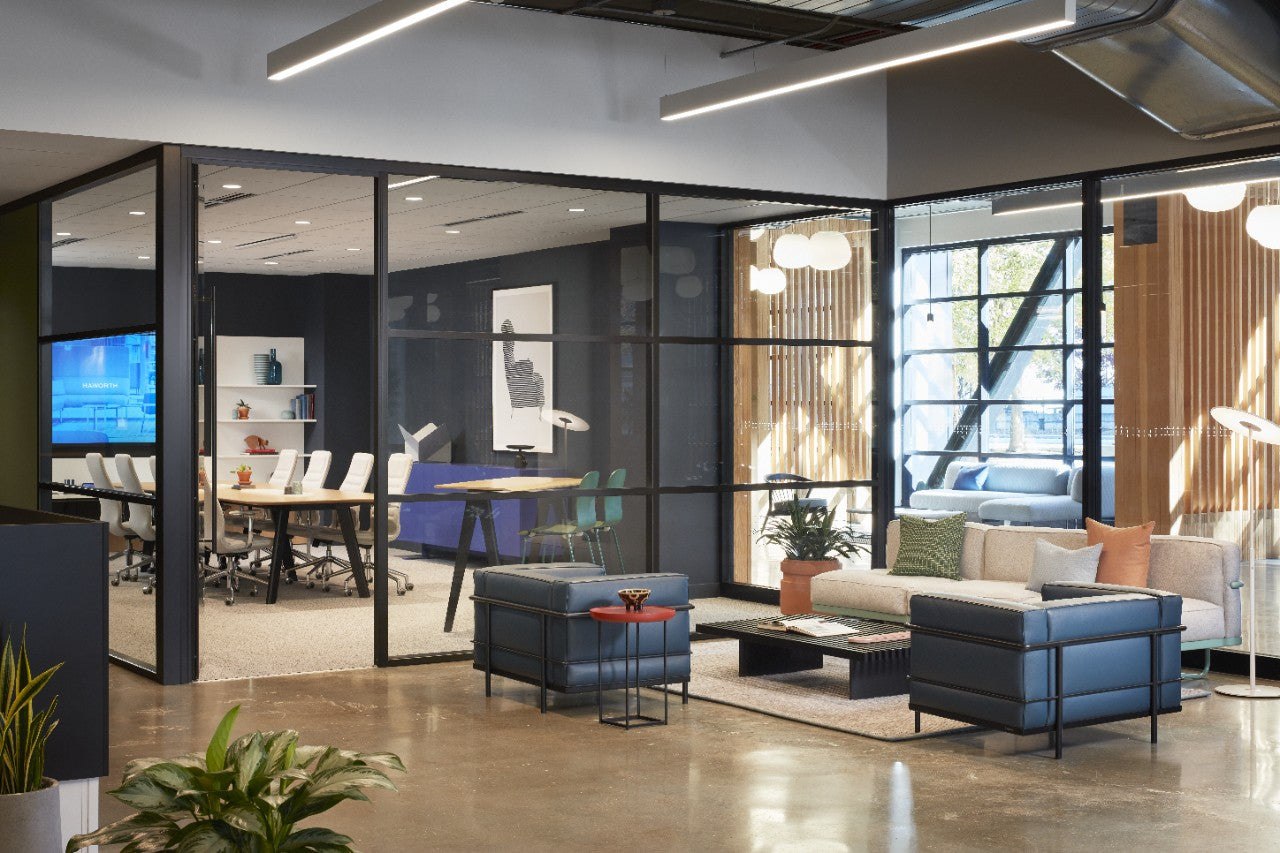 Modern office interior with glass walls, furniture, and decor.