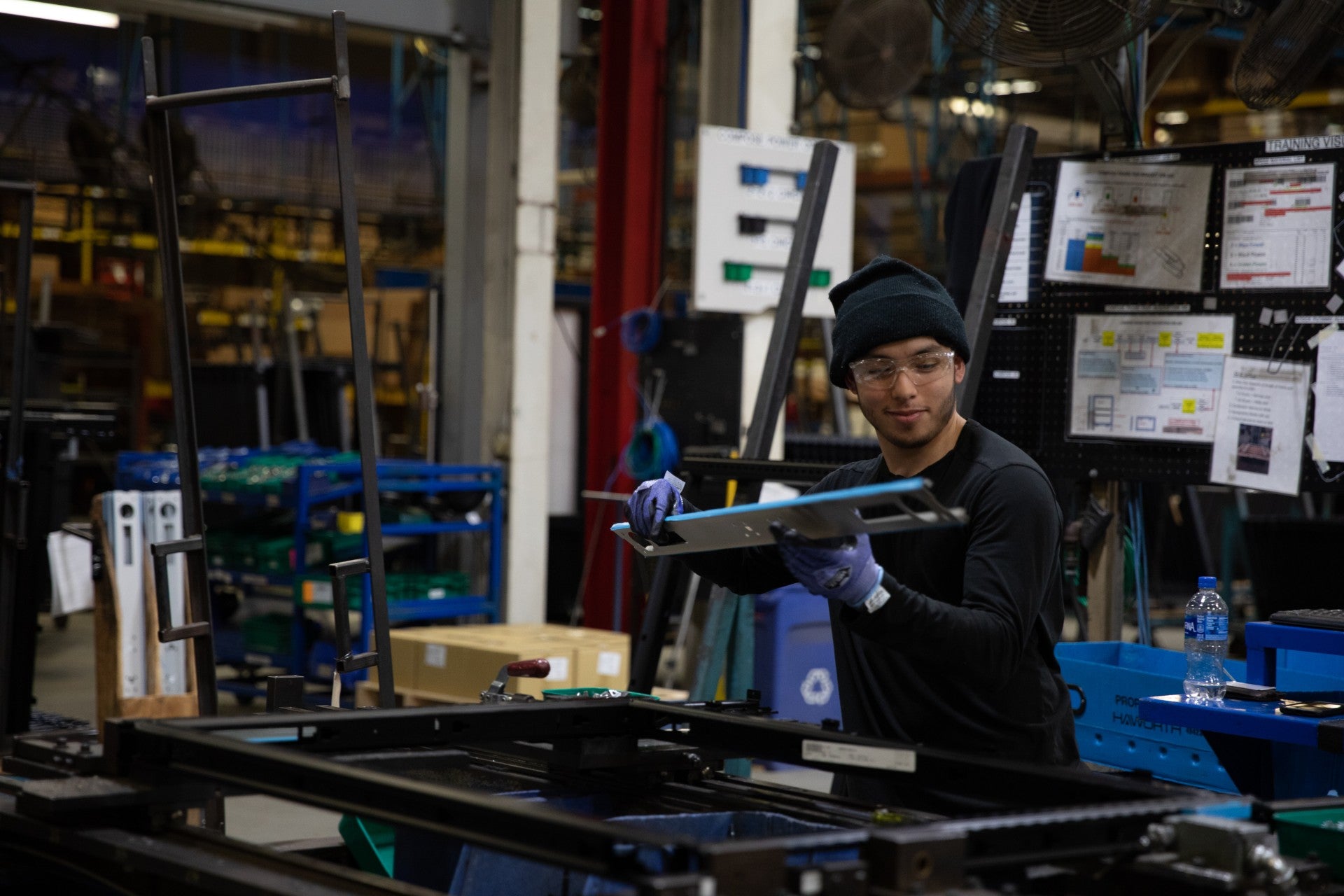 Person working in a factory setting with machinery and equipment around