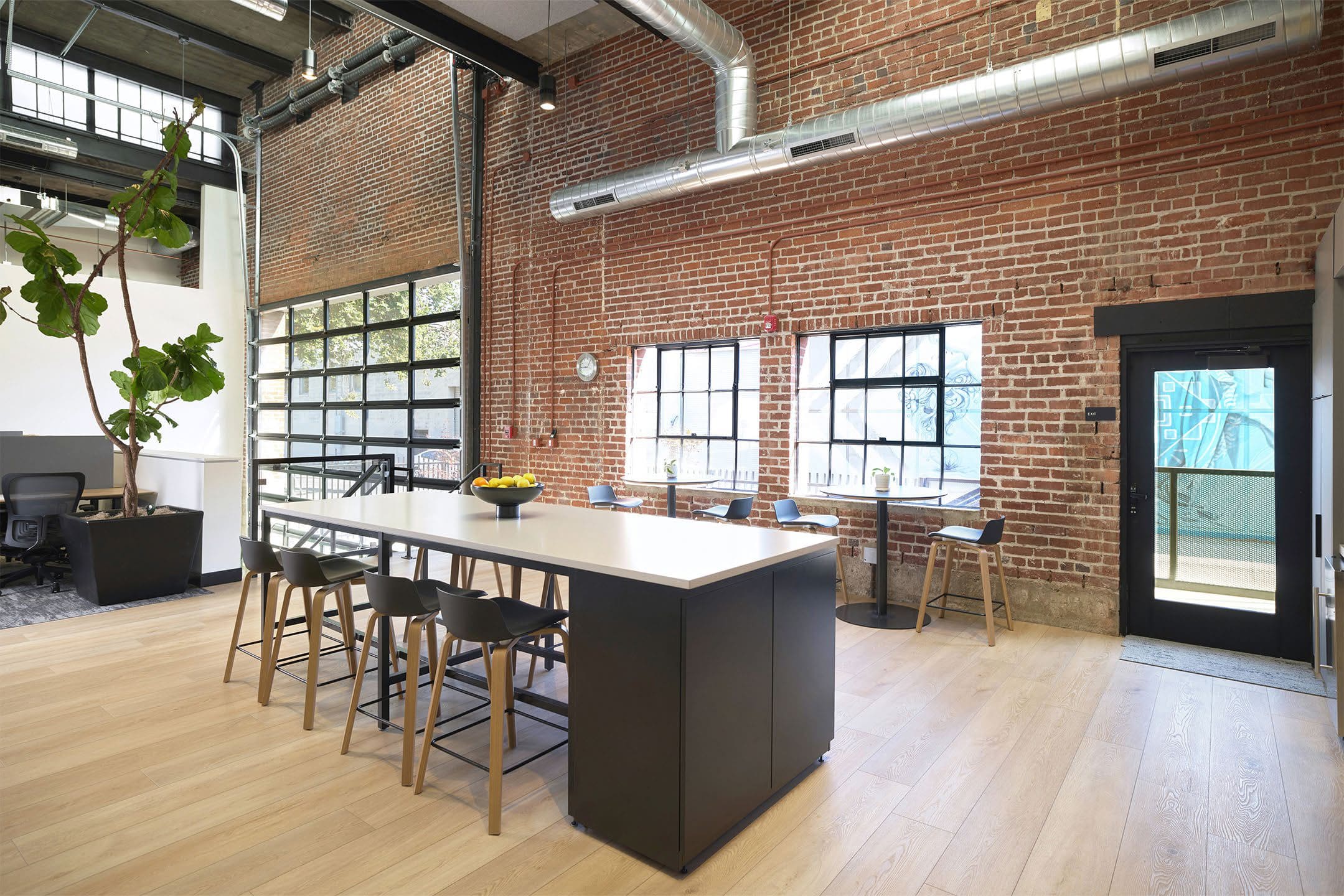 Modern kitchen with brick wall and large island table
