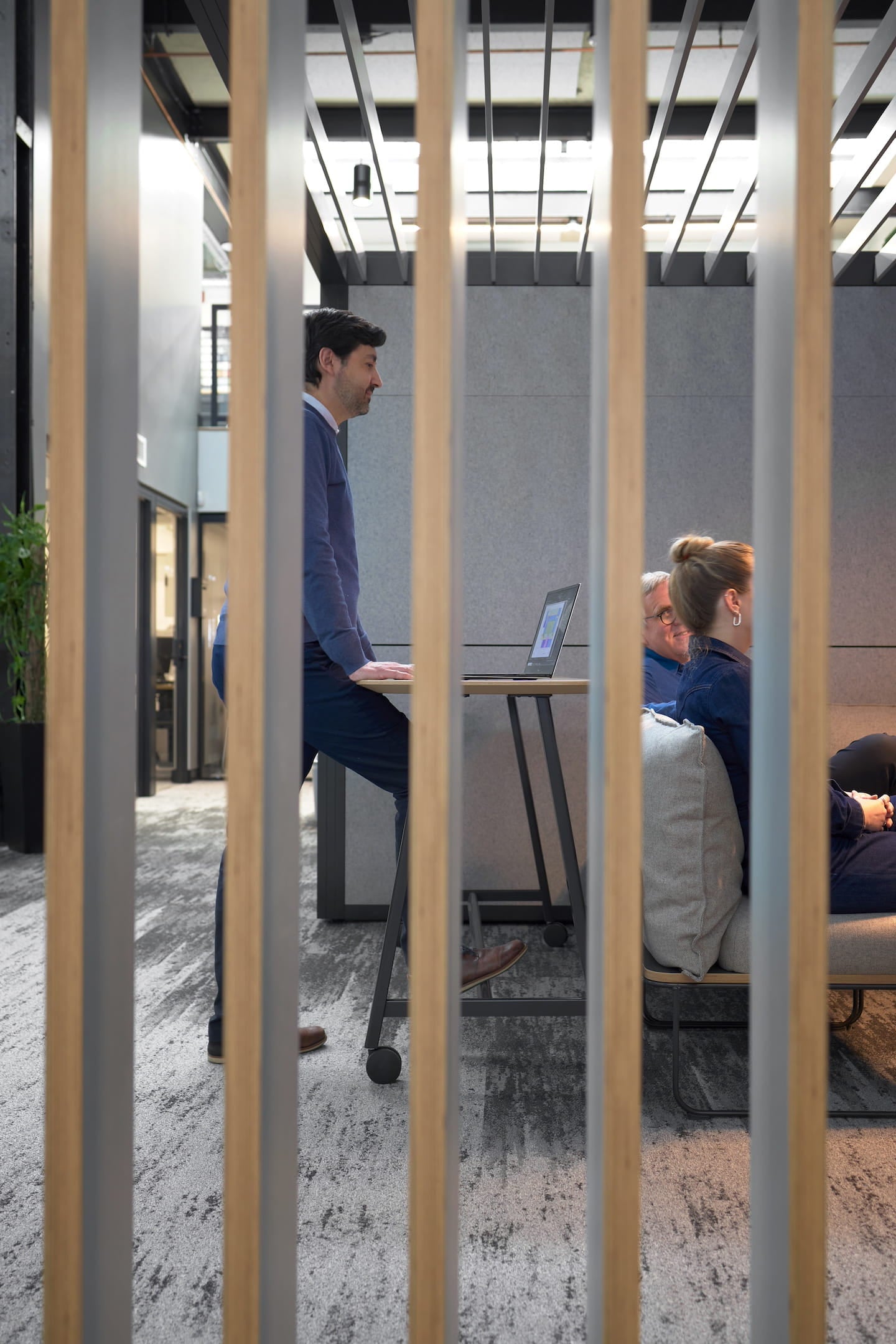 People working in a modern office setting with glass partitions.