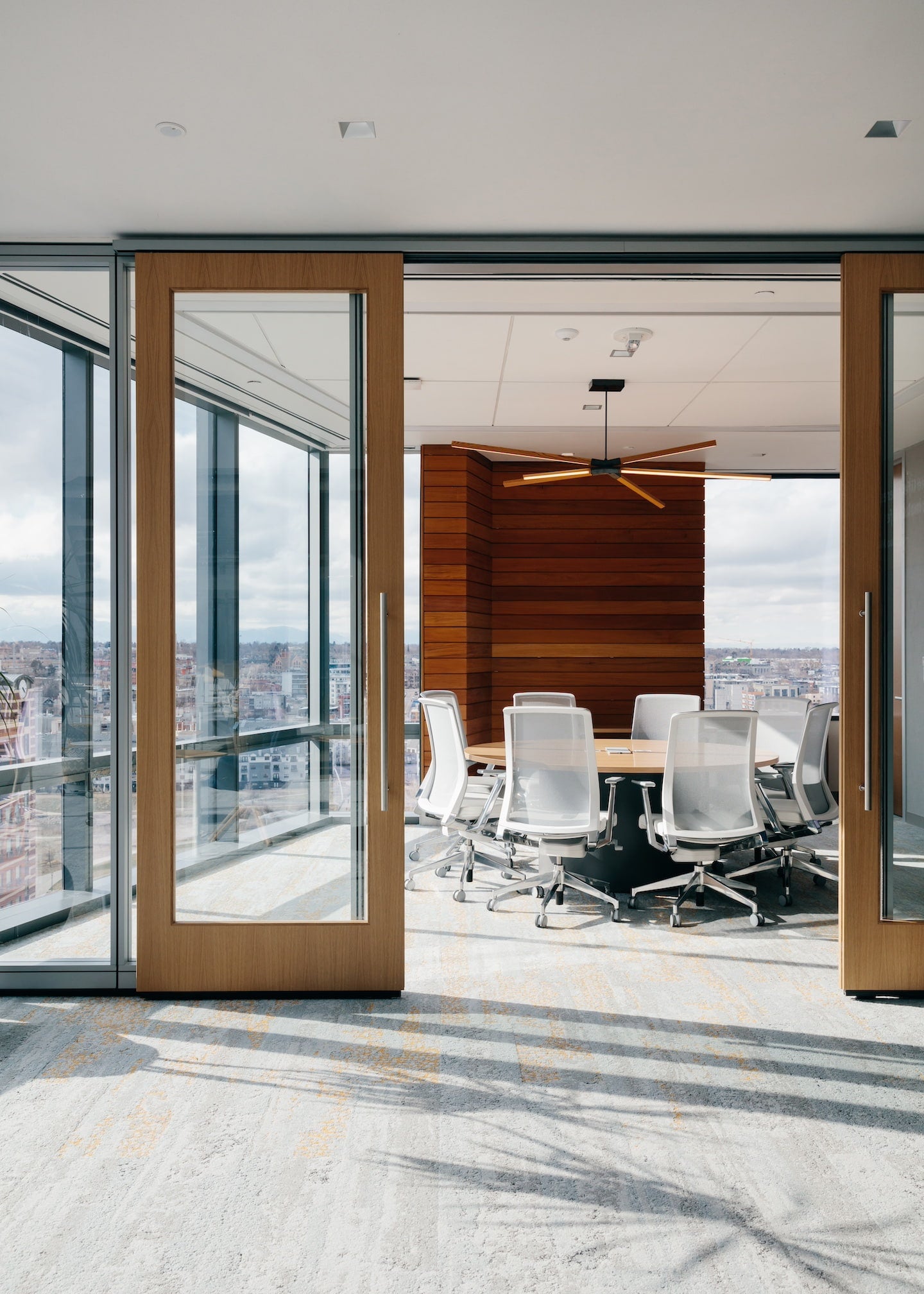Modern conference room with large windows offering a cityscape view.