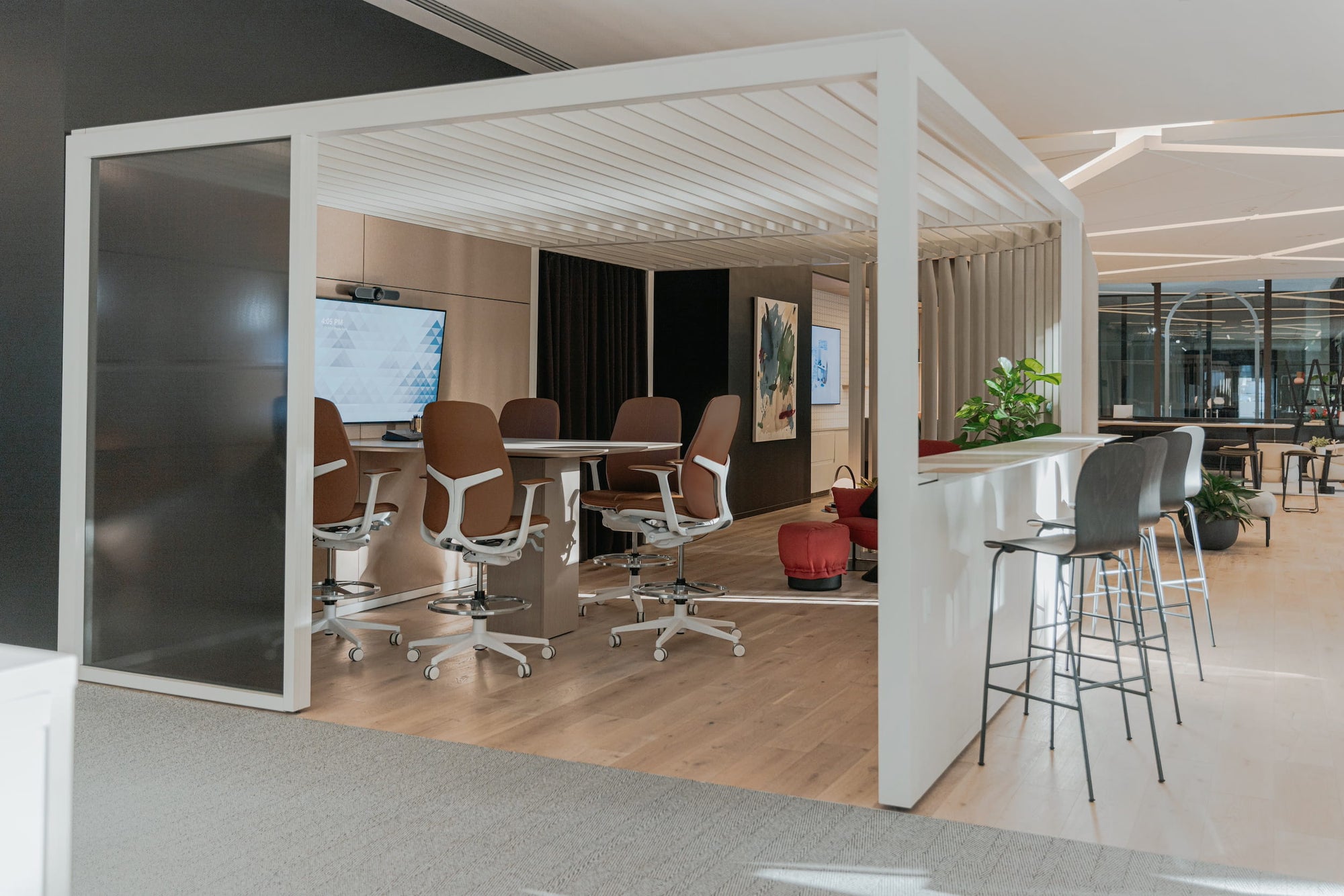Modern office space with a glass partition, chairs, and a counter.