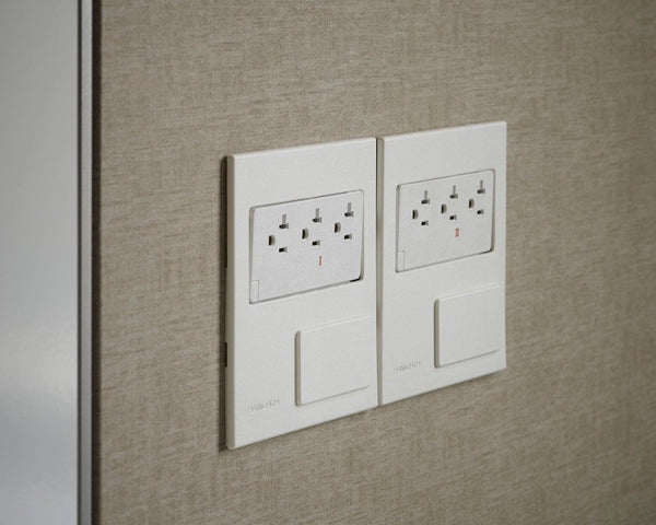 Two electrical outlets on a textured beige wall.