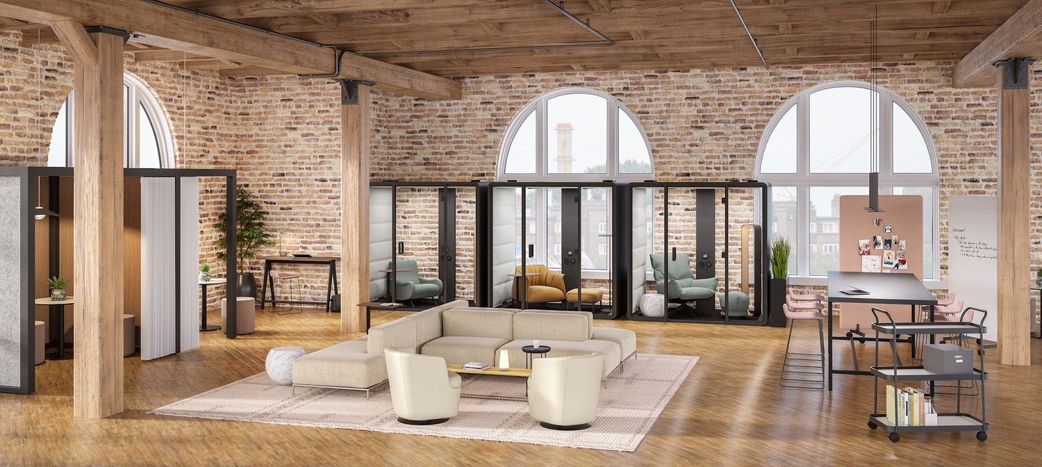 Modern office interior with a large open space featuring a couch, coffee table, and office furniture.