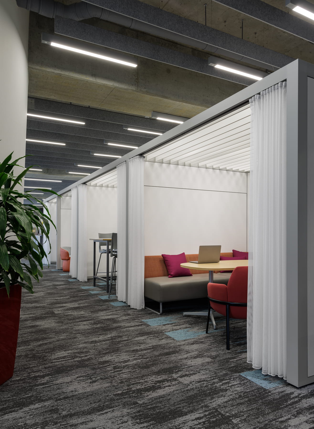 Modern office space with privacy screens and seating area.