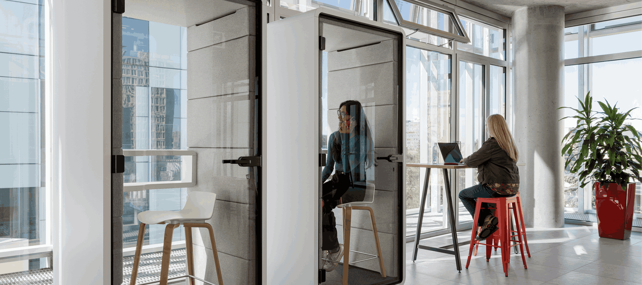 Person working in a modern office with a privacy pod.